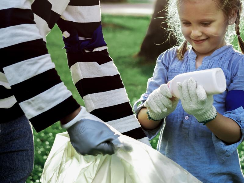 Pige og dame samler skrald i stor sæk